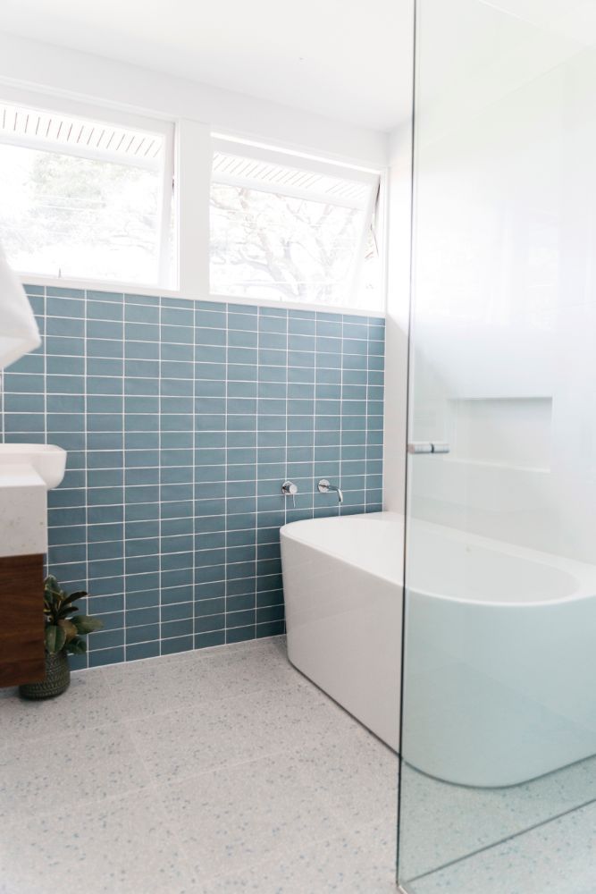 Mid Century modern bathroom with back to wall bath by Bella Vie Interiors
