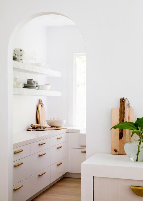 curved arched doorway unique handles brass white cabinetry