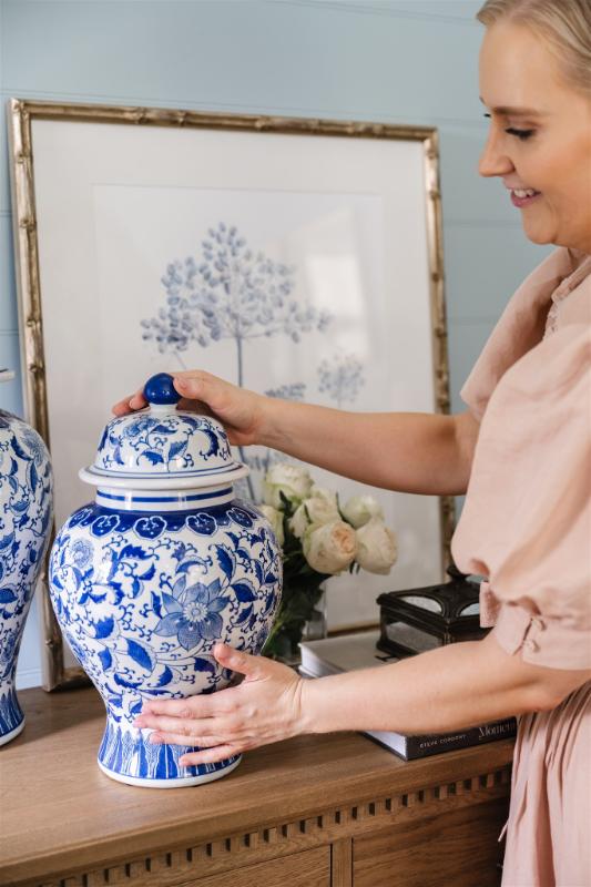 Julia styling blue and white ginger jars atop a timber console in a soft blue bedroom, showcasing Bella Vie Interiors’ thoughtful approach to detail and layering.