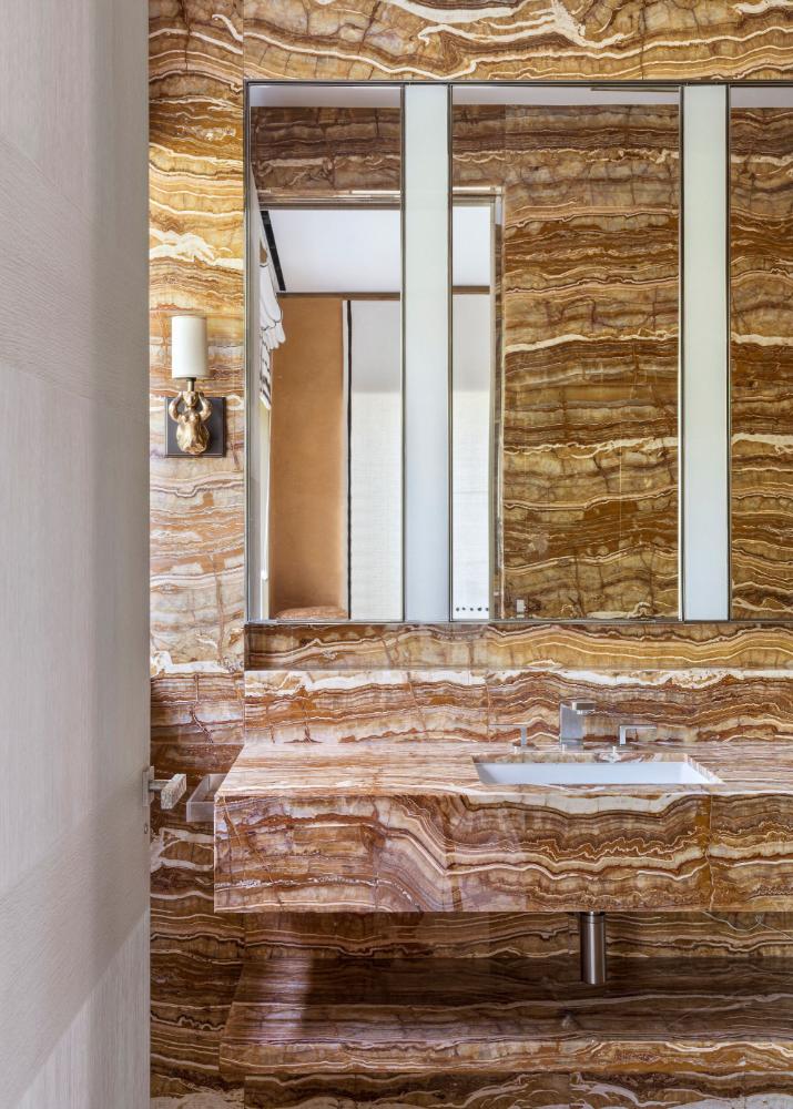 peter-marino-dramatic-onyx-powder-room-full-slab-stone-walls-integrated-vanity